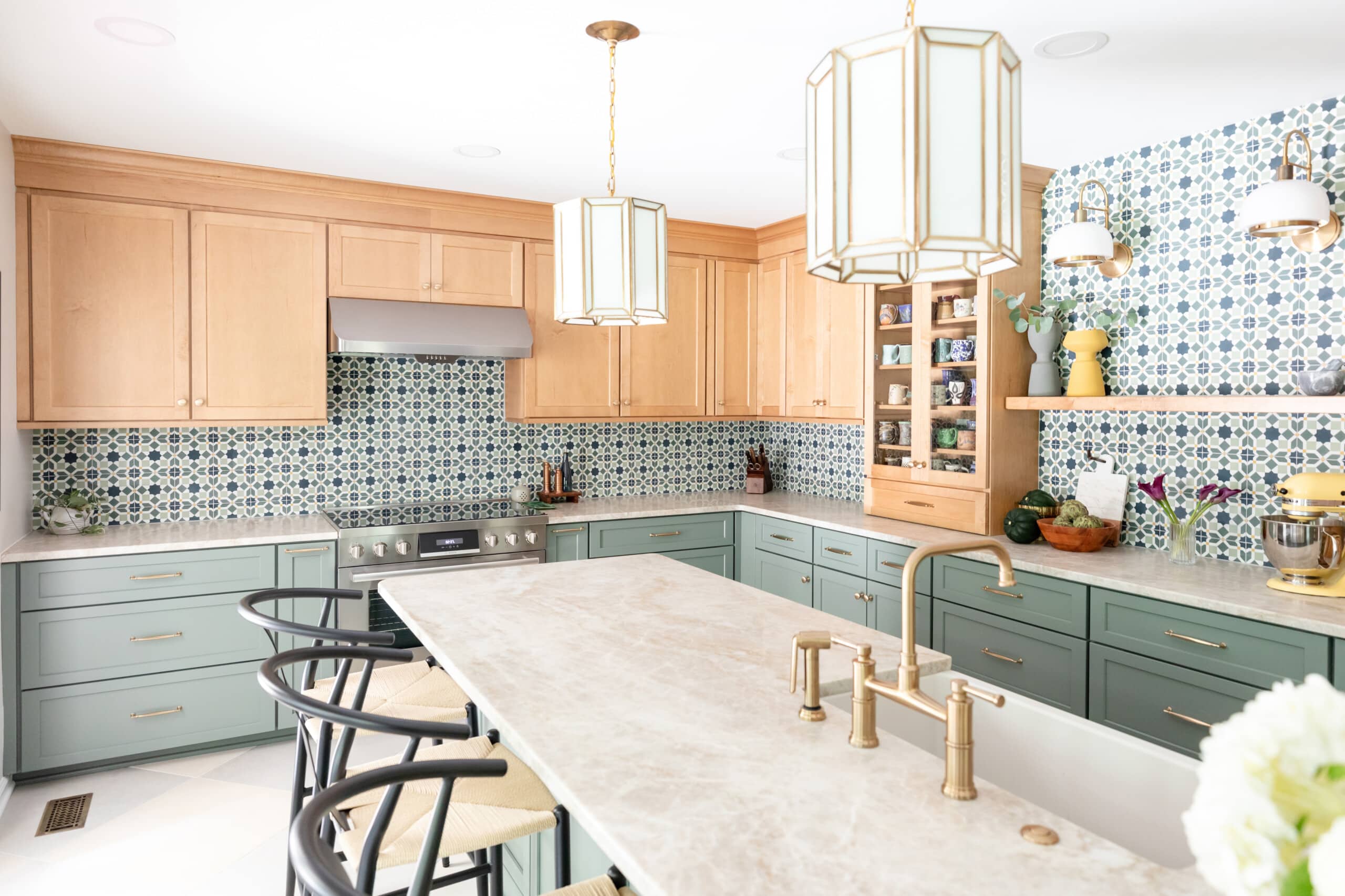 Diagonal view of kitchen showcasing light fixtures, brass hardware, natural textures and earth tones.