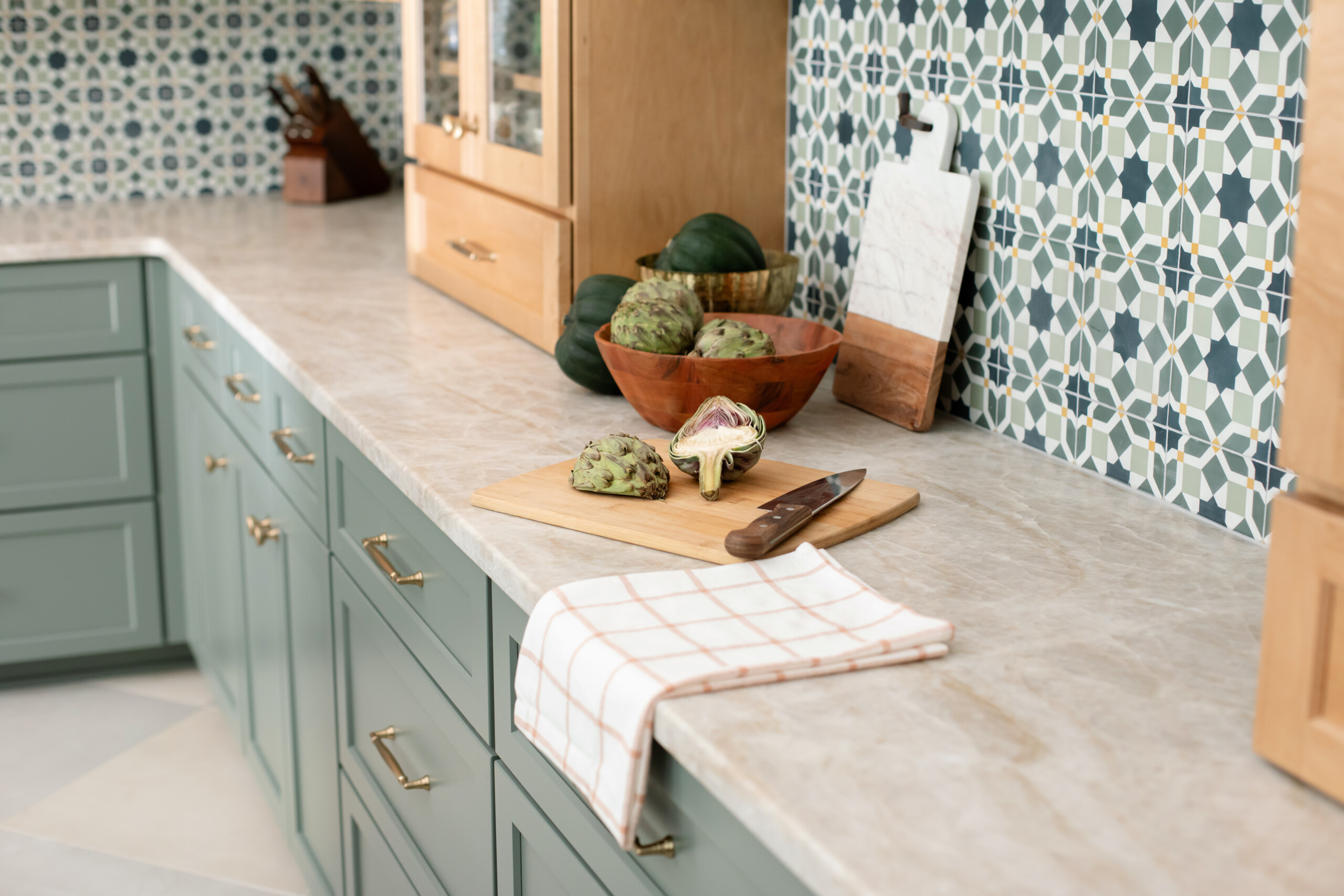 View of marble counters with brass hardware and Moroccan patterns, highlighting kitchen space.