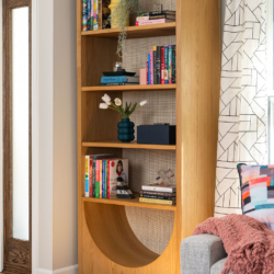 Geometric bookshelf styled with personal touches, geometric textiles, and fun pops of color.