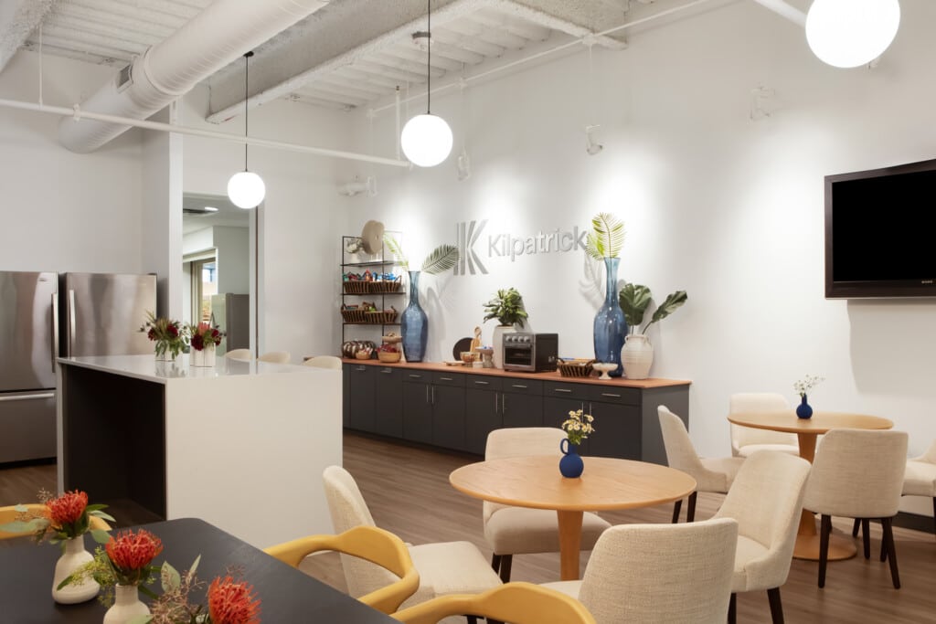 Kitchenette, countertop and tables in a workplace breakroom designed for employee wellness - TEW Design Studio