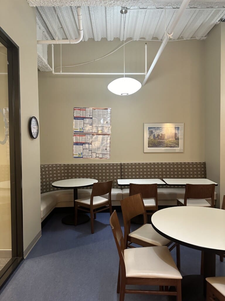 Full booth along wall with opposite tables and chair workplace breakroom designed for employee wellness - TEW Design Studio